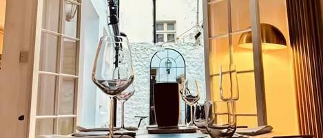 A dining area with a table set for two, a wine glass, and a candle holder.