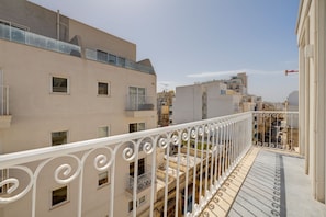 A residential building with balconies, a clear sky, and a narrow street below. - Trendy 3BR Home by the Waterfront (Gzira)