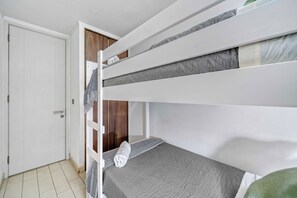 A bunk bed with a grey mattress and a white headboard. - Ñuñoa Botanic 2D - Estacionamiento y AC (Ñuñoa)