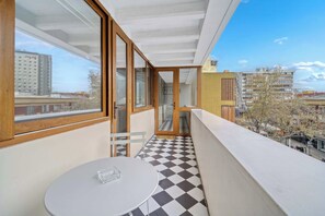 A balcony with a checkered floor, a table, and a chair. - Acogedor departamento bohemio en Providencia (Providencia)