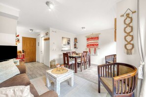 A modern living room with a sofa, coffee table, and dining area with chairs. - Casa Alicura con Patio a pasos del Centro de Pucón (Pucon)