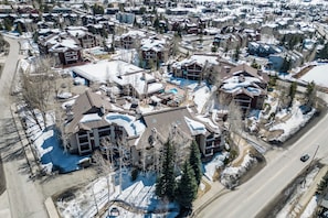 An aerial view of a residential area with multiple houses, some with snow on the roofs, and a road running through the middle. - Near the Ski Area | Cozy Fireplace & Ski Shuttle (Steamboat Springs)