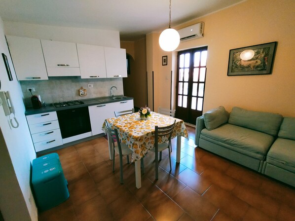 A compact living space with a kitchen, dining area, and a sofa.
