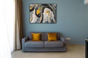 A living room with a grey sofa, two mustard yellow cushions, and a large abstract painting on the wall. - Bright and Modern 2BR Penthouse, St Julian's (St. Julian's)