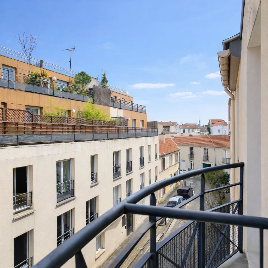 Un immeuble à plusieurs étages doté de balcons, un ciel dégagé et une vue sur la rue.