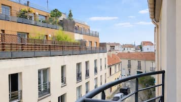 Un immeuble à plusieurs étages doté de balcons, un ciel dégagé et une vue sur la rue.