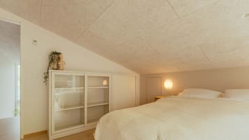 Een slaapkamer met een bed, een kledingkast en een nachtkastje.