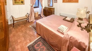 A bedroom with a bed, a bench, a dresser, a lamp, and a rug.