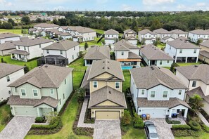A residential area with multiple houses, each with a garage and a lawn. - Magical Moments at Reunion Village Retreat (Kissimmee)