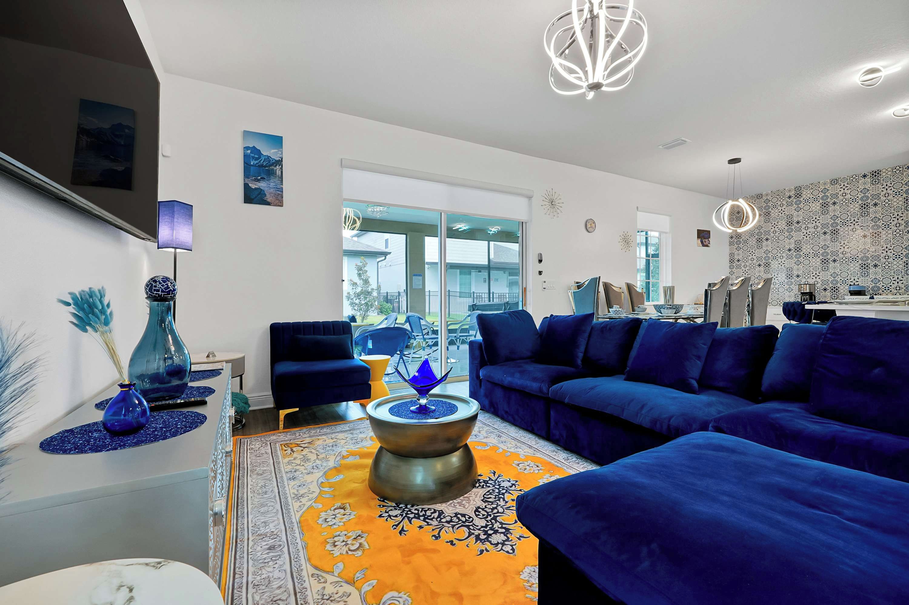 Una sala de estar moderna con un sofá azul, una mesa de centro y un jarrón decorativo.