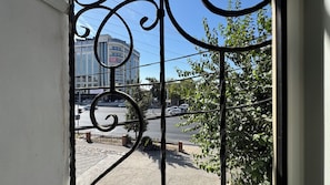 A view through a metal gate with a building in the background. - ARYANA KABUL HOTEL (Tashkent)