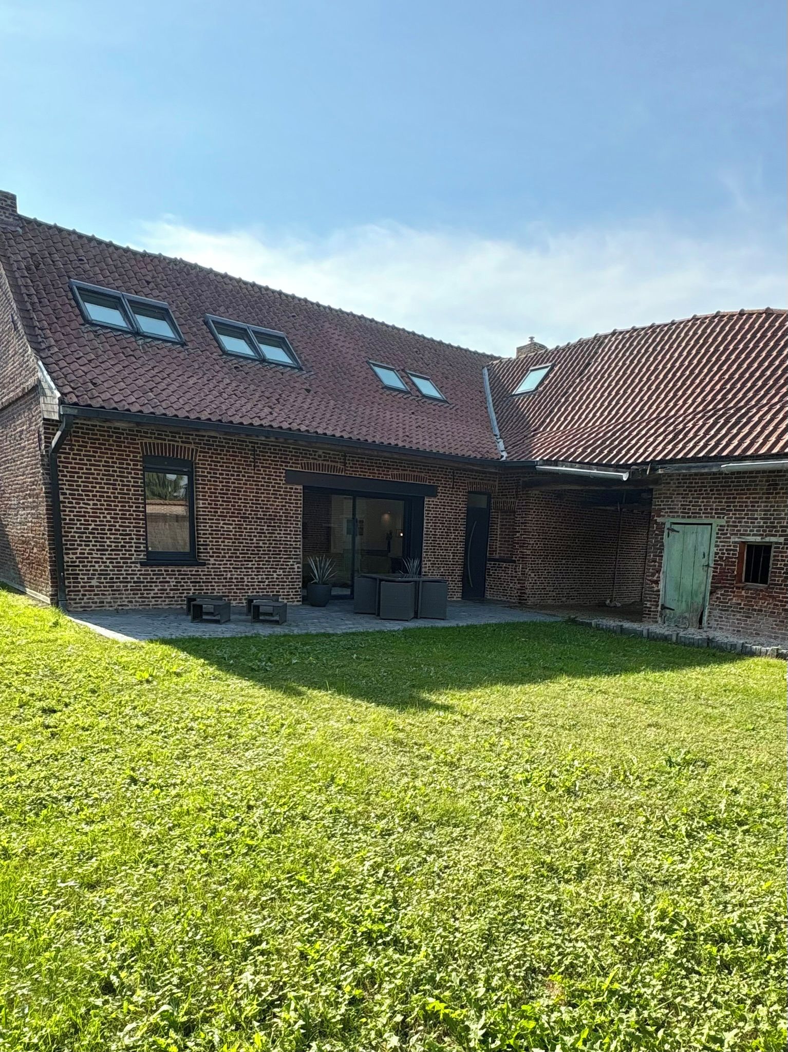 Un bâtiment en briques doté d’un toit en pente et de nombreuses fenêtres.