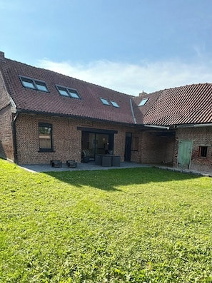 A brick building with a sloped roof and multiple windows.
