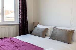 A hotel room with a bed, a window, and a radiator. - Contractor-Ready 7BR Bristol Home | Parking + WiFi (Bristol)