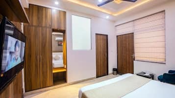 A hotel room with a bed, wardrobe, television, and a ceiling fan.