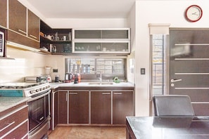 A compact kitchen with a stove, sink, and cabinets.