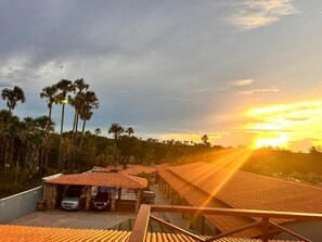 A resort with multiple buildings, a parking area, and palm trees.