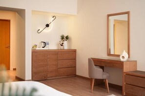 A bedroom with a wooden dresser, a desk with a mirror, a chair, and a bedside table. - The 88th Signature by Maran Hospitality (New Cairo)