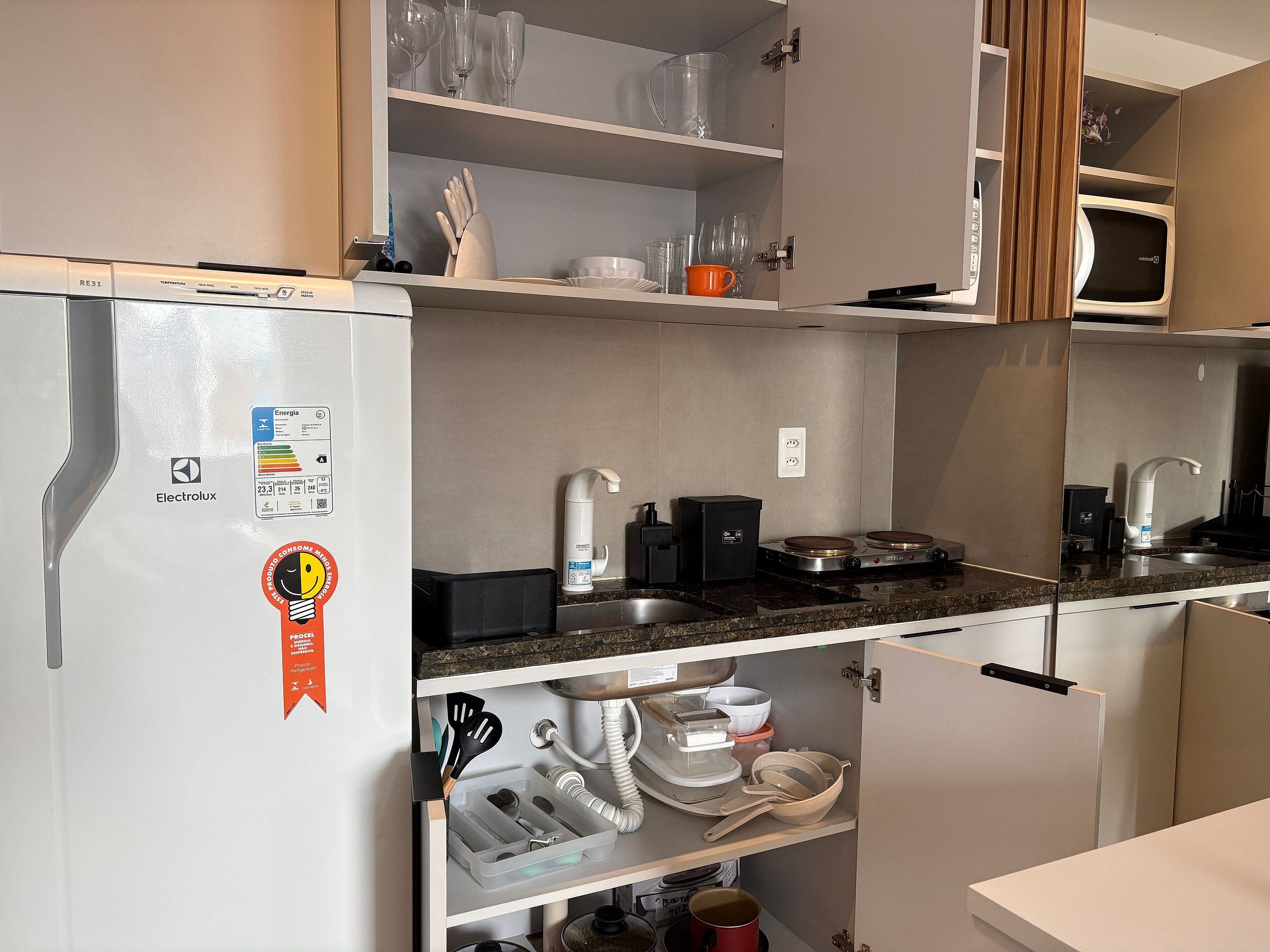 Une cuisine compacte équipée d’un réfrigérateur, d’un four à micro-ondes et d’une cuisinière.