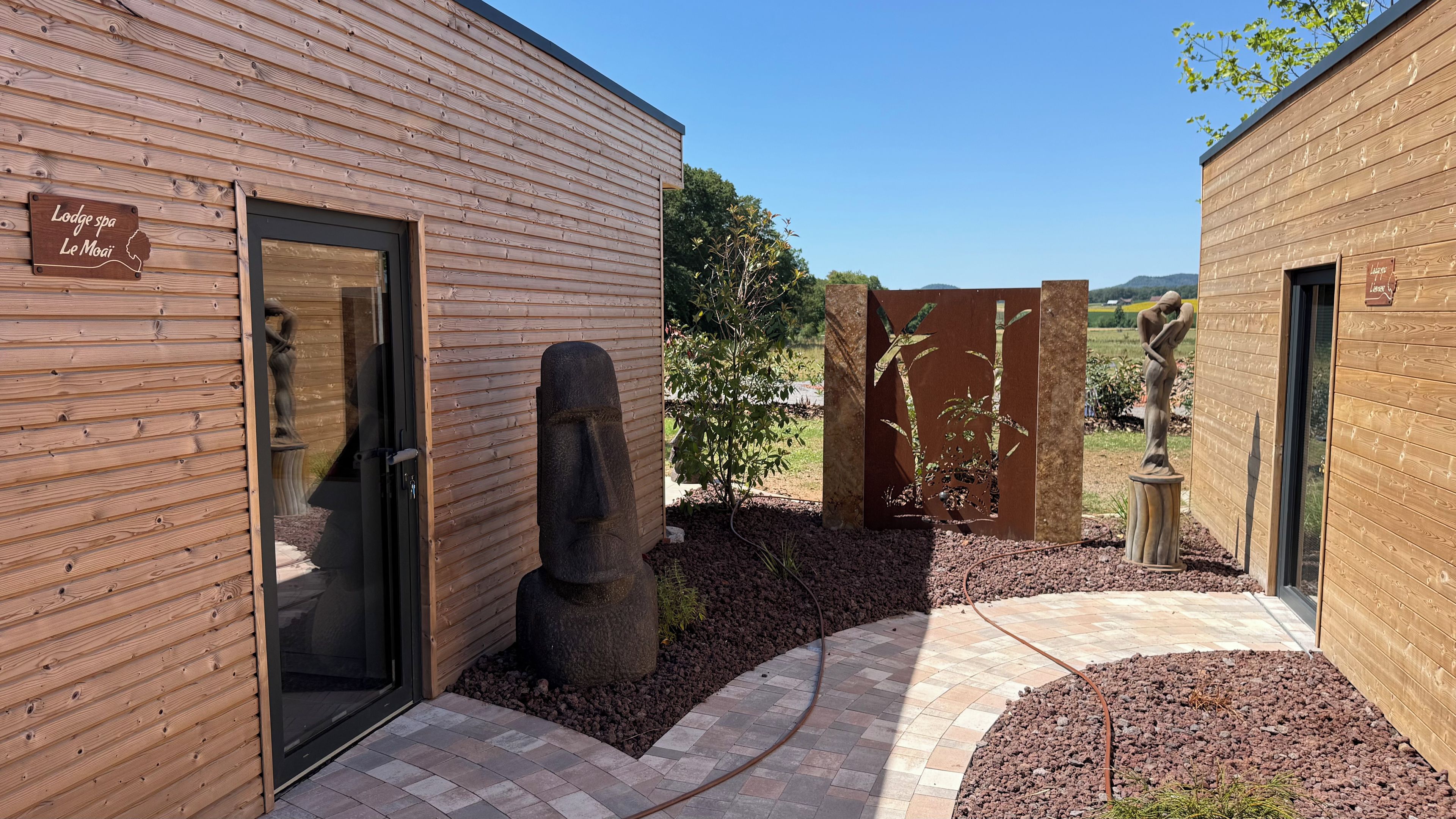 Een houten gebouw met een bord waarop 'Lodge spa Le Moai' staat.