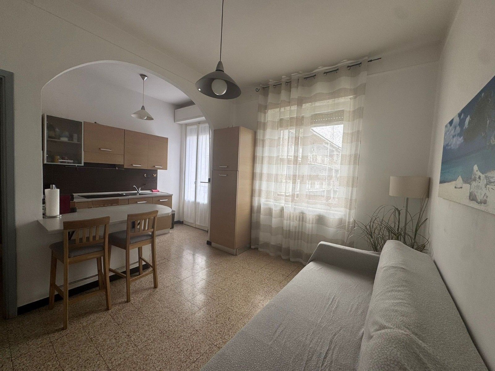 A compact living space with a kitchenette, a dining area, and a sofa.