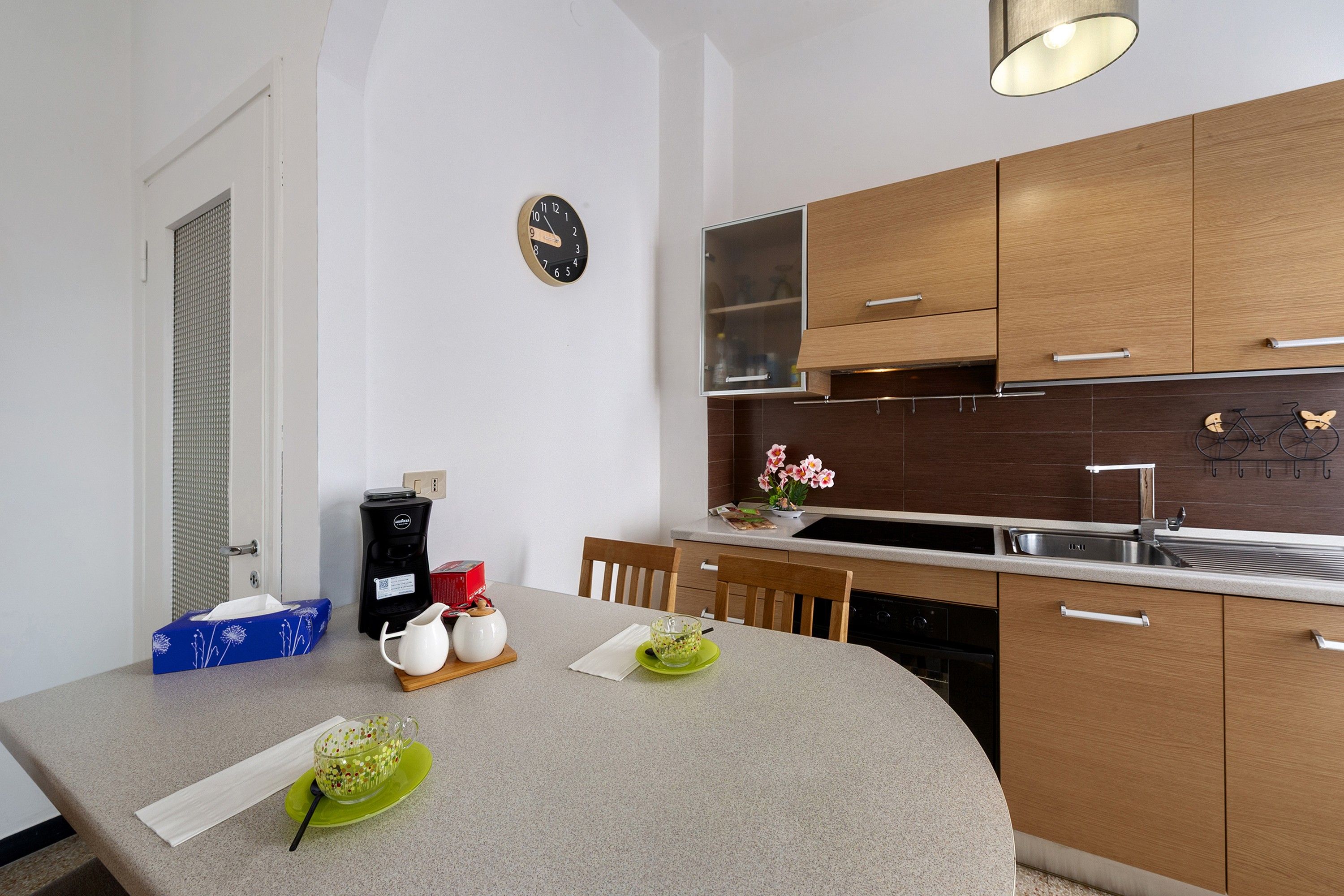 Una cucina moderna con mobili in legno, forno a incasso e lavello in acciaio inossidabile.