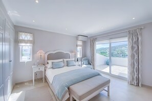 A bedroom with a large bed, bedside tables, a nightstand, a window with curtains, and a view of the outdoors. - Casa das oliveiras, beautifully situated villa, with mature garden and sw.pool. (Loulé)