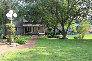 A residential property with a front yard, a pathway leading to a porch, and a large tree. - Unique 4-bedroom Lake House with Private Dock in Vonore (Vonore)