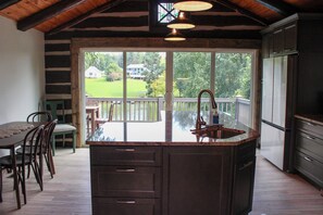 A kitchen with a large island, wooden cabinets, and a view of a lake. - Unique 4-bedroom Lake House with Private Dock in Vonore (Vonore)