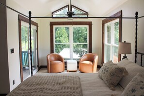 A bedroom with a large bed, two armchairs, a small table, and a lamp. - Unique 4-bedroom Lake House with Private Dock in Vonore (Vonore)
