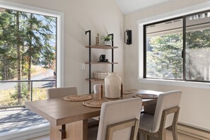 A dining area with a wooden table, woven placemats, and chairs. - Lakeview Retreat + Boat Slip & Waterfront Access (Coeur d'Alene)