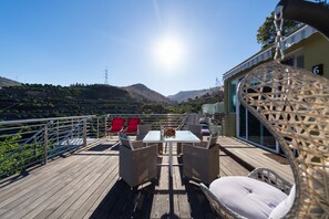 A deck with a table and chairs, overlooking a hilly landscape. - Holidays & Health in Finca Oasis - Apartamento 6 by Viilas Rivero (Telde)
