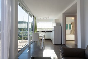 A modern kitchen with a dining area, a balcony with a view, and a separate bedroom. - Holidays & Health in Finca Oasis - Apartamento 6 by Viilas Rivero (Telde)