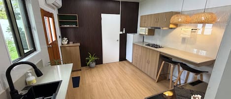 A modern kitchen with a built-in stove, a sink, and a window.