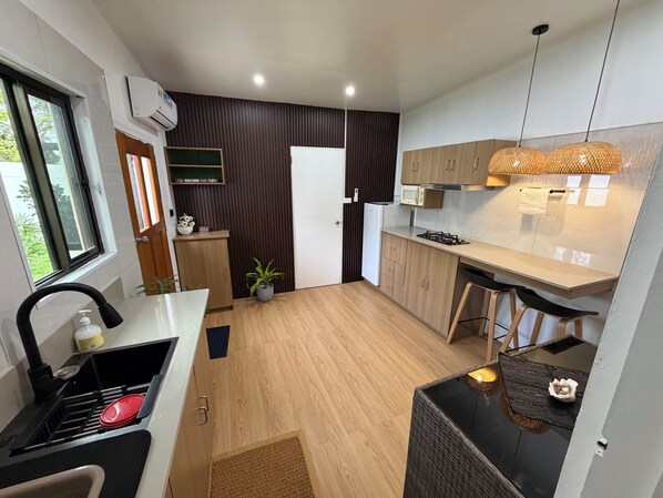 Una cocina moderna con estufa integrada, un lavamanos y una ventana.
