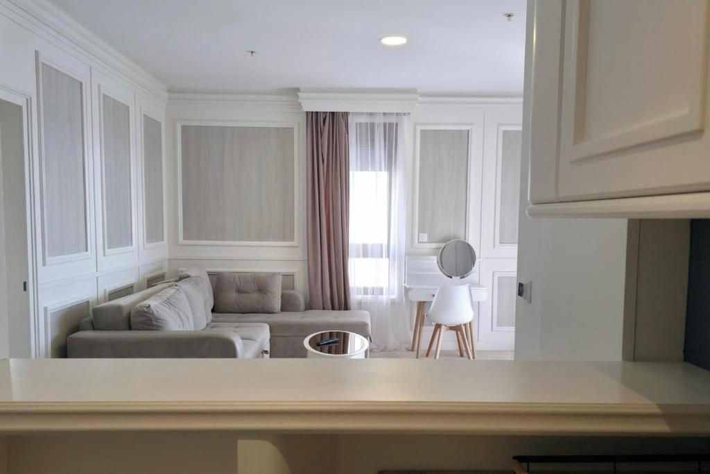 A modern living room with a sofa, a small table, and a mirror.