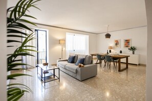 A modern living room with a sofa, coffee table, and dining area. - Superlative 3BR in the Heart of Sliema (Sliema)