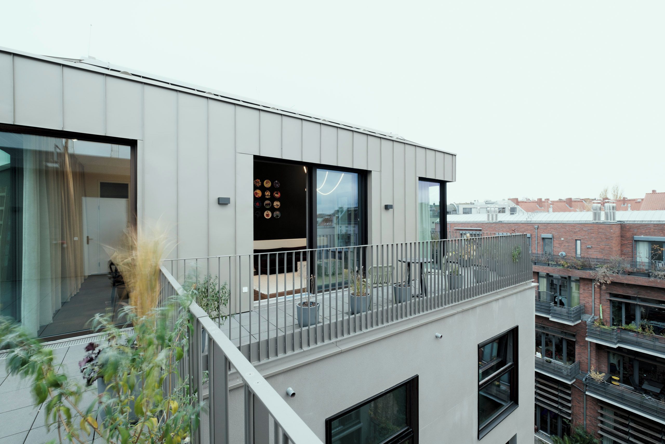 Un edificio moderno con balcón, amplios ventanales y vistas a la ciudad.