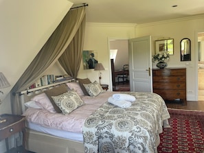 A bedroom with a bed, a dresser, a desk, and a chair.