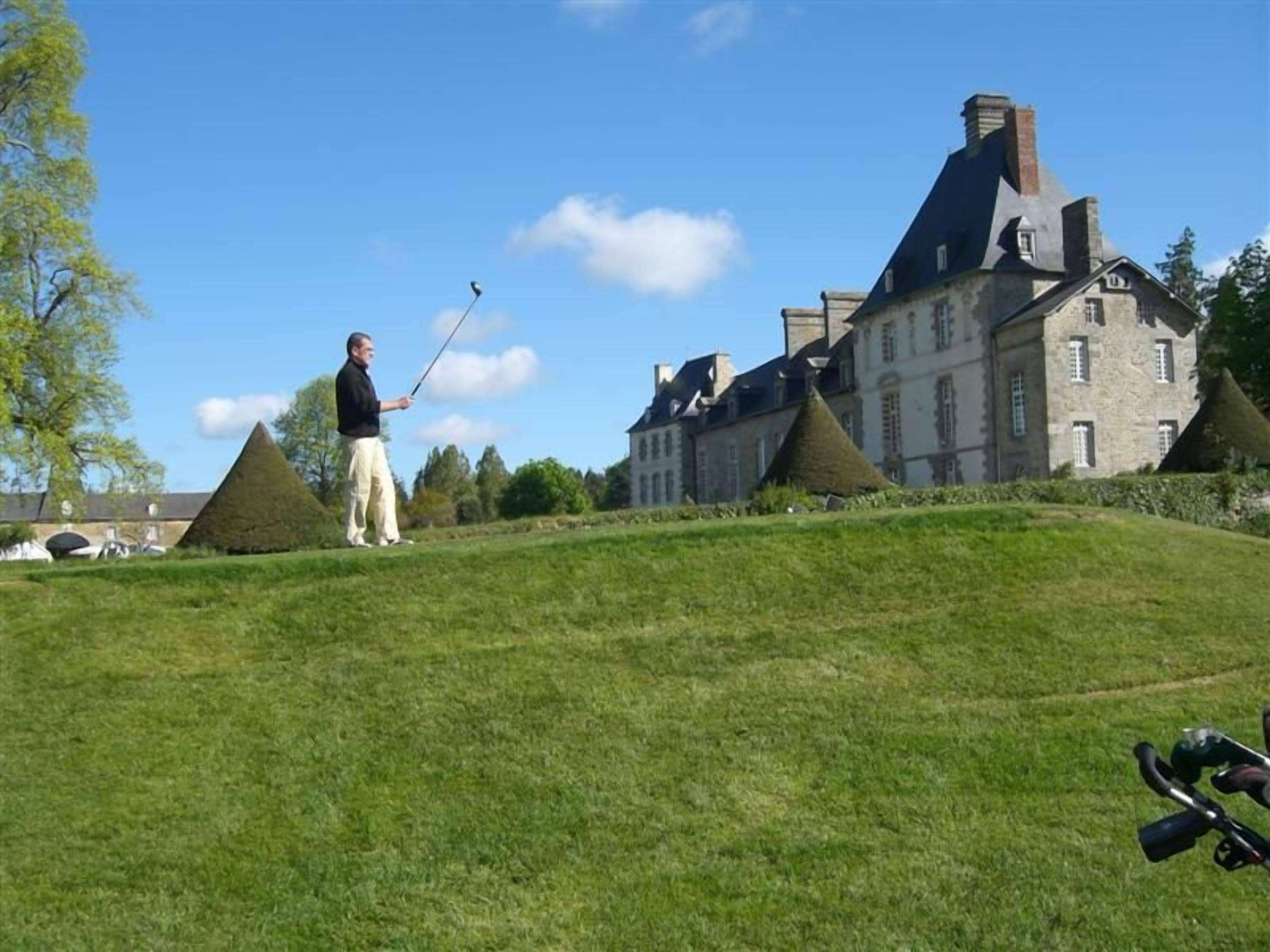 A golf course with a large building in the background.