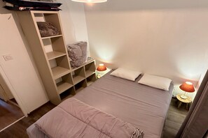 A bedroom with a bed, a wardrobe, and two bedside lamps. - Alpine holiday home with balcony (Mont-Dore)