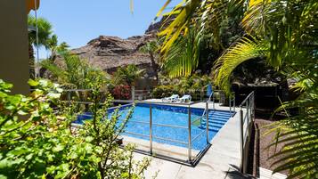 Una piscina con vista despejada a una montaña rocosa en el fondo.