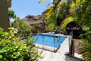 Una piscina con vista despejada a una montaña rocosa en el fondo.