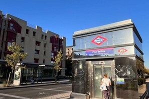 A metro station with a glass shelter and a sign indicating 'Pinar del Rey.' - Pet-Friendly Stay in Madrid (Madrid)