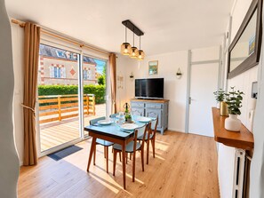 Eine moderne Küche mit Essbereich, einem Fernseher und Blick ins Freie.
