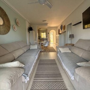 A living room with two sofas, a coffee table, and a dining area in the background. - Casa Sunset by Rental Hero (Alcazares, Los)