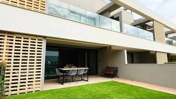 Un edificio moderno de dos pisos con techo plano, amplias ventanas y un césped bien cuidado.