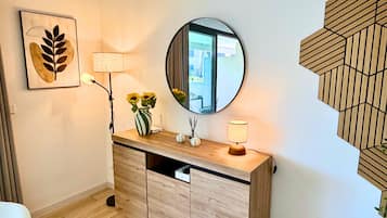 Un baño moderno con tocador de madera, un espejo redondo y un adorno de pared decorativo.