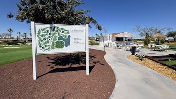Señal de La Reserva Beach Sport Club con un mapa y lista de servicios.