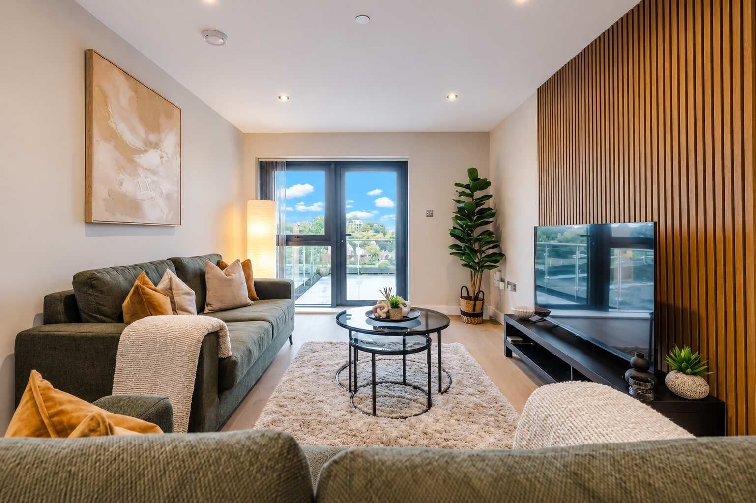 Una sala moderna con sofá, mesa de centro y televisor.